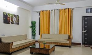 a living room with two couches and a coffee table at Treebo Trend Umal Homestay Ganeshguri in Guwahati
