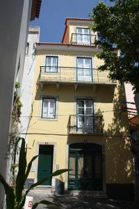 - un bâtiment jaune avec un balcon au-dessus dans l'établissement Se de Lisboa III, à Lisbonne
