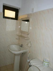 a small bathroom with a sink and a toilet at Tamaro Beach Resort in Hikkaduwa