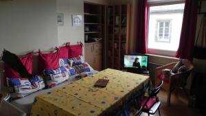 un soggiorno con un tavolo e una televisione di Appartement Clémenceau a Saint Malo