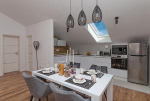a kitchen and dining room with a white table and chairs at Apartment Lungo Mare, Centar in Makarska