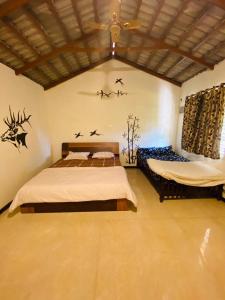 a bedroom with two beds and birds on the wall at Trippr Chikkamagaluru in Chikmagalūr