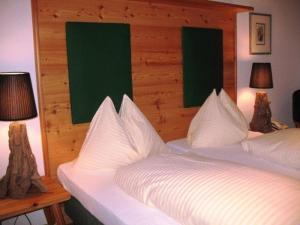 1 Schlafzimmer mit 2 Betten mit weißer Bettwäsche und 2 Lampen in der Unterkunft Haus Edith in Maria Wörth