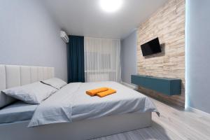 Un dormitorio con una cama con una toalla naranja. en ЖК Парк Ленд метро Васильковская Люкс, en Kiev