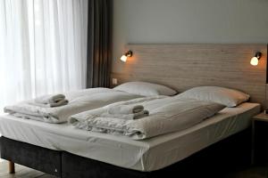 a large white bed with two towels on it at Der Landhof Wolgast in Stolpe auf Usedom