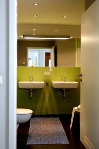 uma casa de banho com 2 lavatórios, um WC e um espelho. em Der Landhof Wolgast em Stolpe auf Usedom