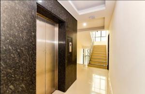 a hallway with a elevator in a building with stairs at Hotel Tri-Star Residency in Cochin