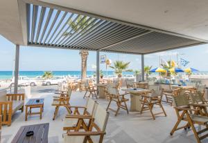 a restaurant with chairs and tables and the beach at Marilyn Apartments in Rethymno