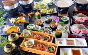 una mesa con muchos platos de comida. en Ryokan Yufusan en Yufu