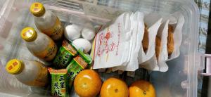 einen Kühlschrank mit Speisen, Orangen und Getränken in der Unterkunft Sports Home in Xingjian