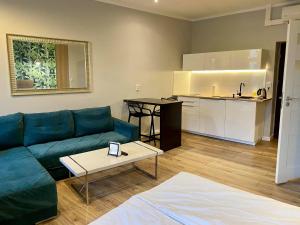a living room with a couch and a table and a kitchen at Apartmenty Mariacka 20 -Self Check-In 24h -Głośniej w weekendy - Noisy on the weekend in Katowice
