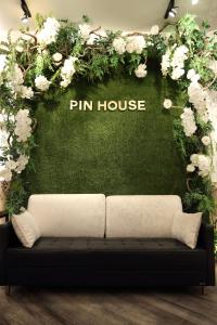 a couch in front of a green wall with flowers at Pin House in Hualien City