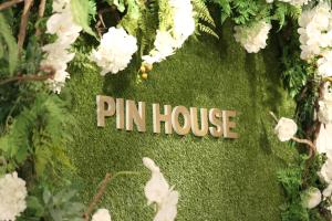 un cartel que dice casa pin en una pared verde en Pin House, en Hualien City