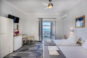 a bedroom with a bed and a desk with a view of the ocean at Irene Hotel - Beachfront in Parikia