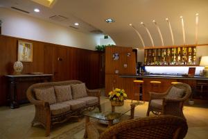 eine Lobby mit einem Sofa und Stühlen sowie einer Bar in der Unterkunft Hotel Maddaloni in Tufino