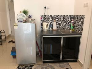 eine Küche mit einer Spüle neben einem Kühlschrank in der Unterkunft Menara U Shah Alam Guest House in Shah Alam