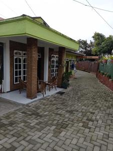 a brick building with two benches on a patio at Kaesa Homestay in Berastagi