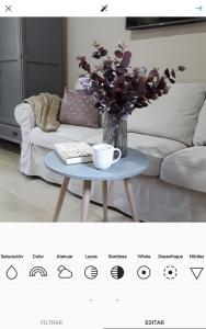 a coffee table with a vase of flowers on it at Hotel Azalea Playa in Chiclana de la Frontera