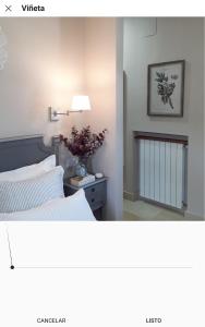 a bedroom with a bed and a vase of flowers on a table at Hotel Azalea Playa in Chiclana de la Frontera