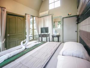 1 dormitorio grande con 1 cama grande con sábanas blancas en Pai Panalee The Nature Boutique Hotel, en Pai