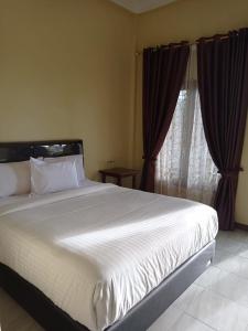 不拉士打宜Kaesa Homestay的卧室里有一张白色的大床和一扇窗户