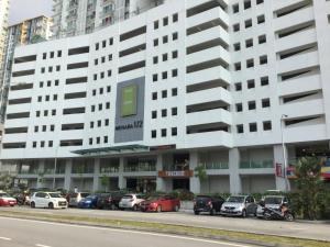 a large white building with cars parked in front of it at Menara U Shah Alam Guest House in Shah Alam