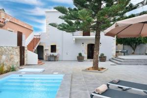 a villa with a swimming pool and a tree at Villa Christini a luxury villa with amazing views in Tzitzifés