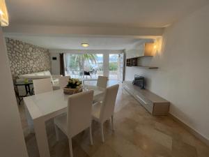 a dining room and living room with a white table and chairs at Villa Cube in Premantura +39 photos