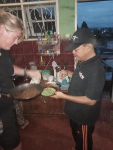 不拉士打宜Kaesa Homestay的男人和女人在厨房里做饭