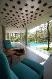 a living room with a couch and tables and a pool at The Birchwood Retreat, Madikeri in Madikeri