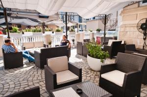 a restaurant with people sitting in chairs and tables at Vigo Grand Hotel in Ploieşti