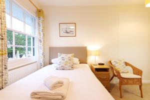 a bedroom with a bed and a chair and a window at Brendon Arms in Bude