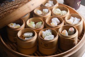 um grupo de pequenos recipientes de madeira cheios de dumplings em Holiday Inn Gwangju, an IHG Hotel em Gwangju