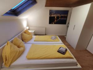 2 łóżka w małym pokoju z żółtą pościelą w obiekcie Linz LIVIA w Linzu