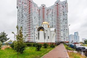 a building in the middle of some tall buildings at N.A.N Apartments on Osokorky in Kyiv