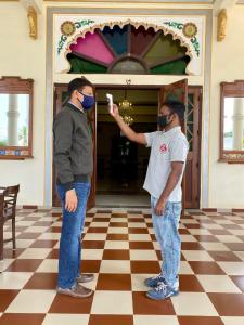two men wearing masks standing in a room at Dowlat Villas Palace-The Heritage in Himatnagar