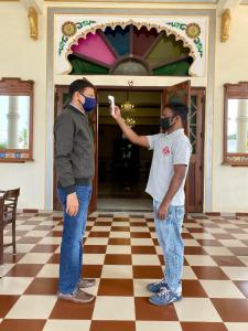 zwei Männer mit Masken in einem Zimmer in der Unterkunft Dowlat Villas Palace-The Heritage in Himatnagar