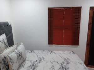 una camera con letto e finestra rossa di Dante Guest house ad Alberton