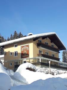 un edificio con nieve delante en Landhaus zur Tanne, en Feld am See