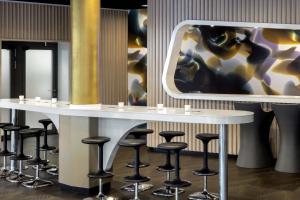 a row of stools around a table with a mirror at prizeotel Erfurt-City in Erfurt