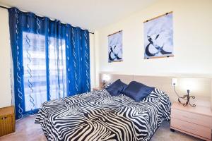 a bedroom with a zebra print bed and a window at Residencial Ventura Park / Royal / Jerez in Salou