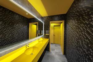 
a bathroom with two sinks and a yellow wall at prizeotel Erfurt-City in Erfurt
