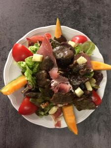 um prato branco com uma salada de carne e legumes em Gite Le Pelens em Saint-Martin-dʼEntraunes