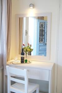 a white dressing table with a mirror and a white chair at Prince Studios in Sami