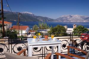 a table on a balcony with a view of the water at Prince Studios in Sami