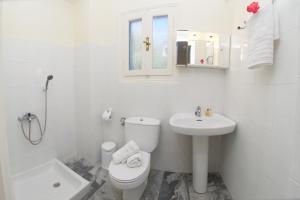 a white bathroom with a toilet and a sink at Prince Studios in Sami
