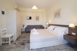 a bedroom with a large white bed and a chair at Prince Studios in Sami