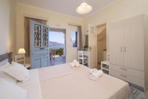 a bedroom with a large white bed and a balcony at Prince Studios in Sami