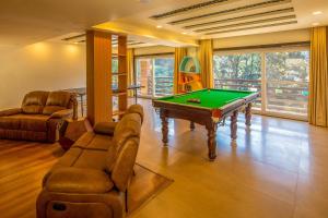 uma sala de estar com uma mesa de sinuca e um sofá em Golden Bliss Cottage by VEO - Part of StayVista em Rāmgarh