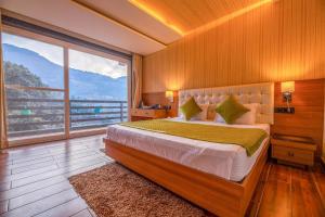 um quarto com uma cama grande e uma janela grande em Golden Bliss Cottage by VEO - Part of StayVista em Rāmgarh